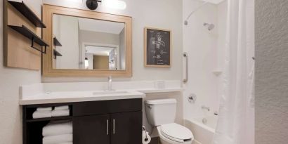 Sonesta Simply Suites Irvine East Foothill guest bathroom, including mirror, lavatory, sink, and bath with a shower.