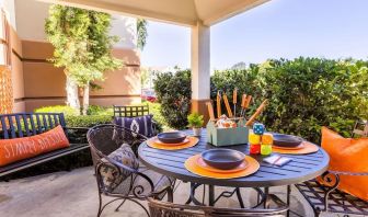 Sonesta Simply Suites Irvine East Foothill co-working space beneath a gazebo, featuring a round table and pleasant greenery.