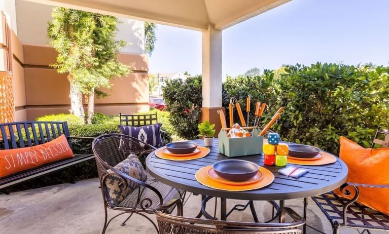 Sonesta Simply Suites Irvine East Foothill co-working space beneath a gazebo, featuring a round table and pleasant greenery.