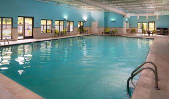 Sonesta Select Nashville Airport Suites’ indoor pool is brightly lit, has chairs by the side, and is adjacent to the patio.