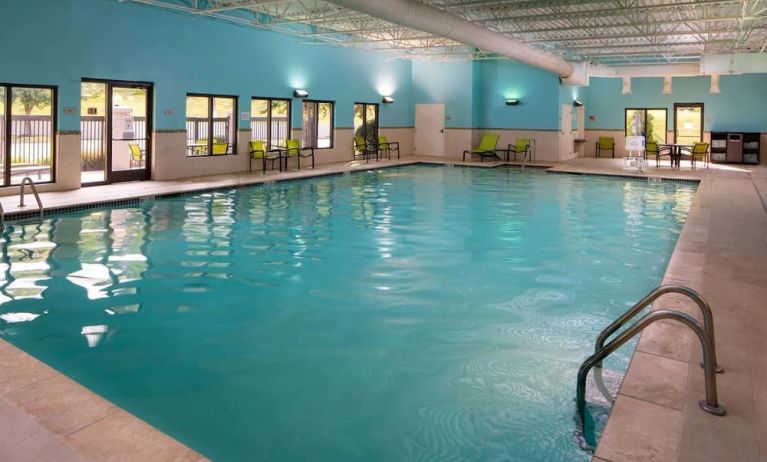 Sonesta Select Nashville Airport Suites’ indoor pool is brightly lit, has chairs by the side, and is adjacent to the patio.