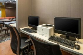 The hotel business center includes a pair of computer workstations and a printer.