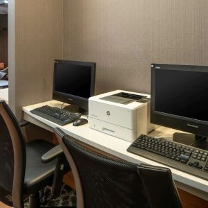 The hotel business center includes a pair of computer workstations and a printer.