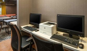 The hotel business center includes a pair of computer workstations and a printer.