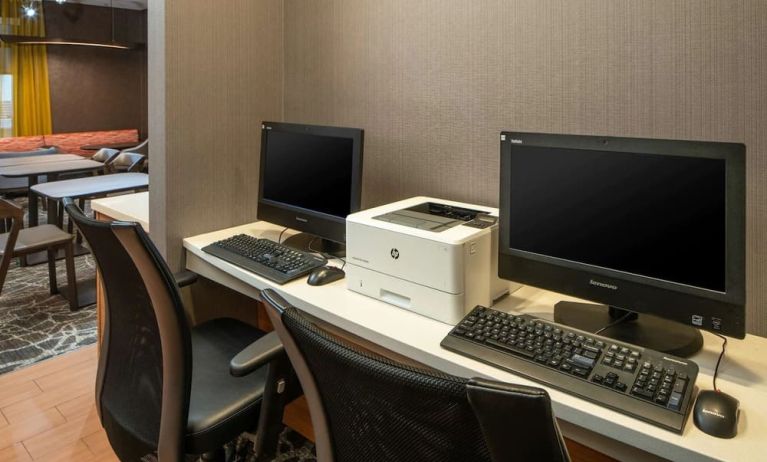 The hotel business center includes a pair of computer workstations and a printer.