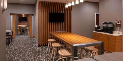 Sonesta Select Nashville Airport Suites meeting room, with long wooden table and a wall-mounted television.