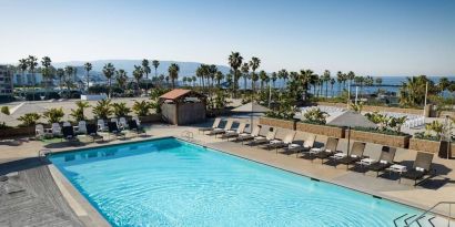 Stunning outdoor pool area with pool chairs at Sonesta Redondo Beach & Marina.