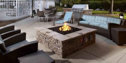 Sonesta ES Suites Cincinnati - Blue Ash’s patio area features a fire pit, plus tables and chairs, and a barbecue.