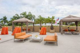 The hotel’s patio has comfortable sofa seating, coffee tables, and potted palm trees.