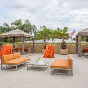 The hotel’s patio has comfortable sofa seating, coffee tables, and potted palm trees.