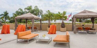 The hotel’s patio has comfortable sofa seating, coffee tables, and potted palm trees.