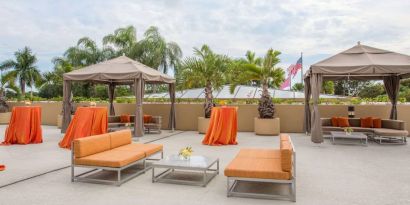 The hotel’s patio has comfortable sofa seating, coffee tables, and potted palm trees.