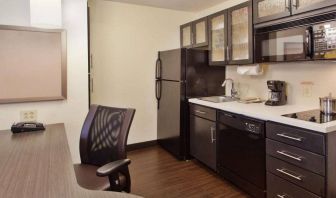 Sonesta Simply Suites Cleveland North Olmsted Airport guest room workspace desk and chair, and adjacent kitchenette.