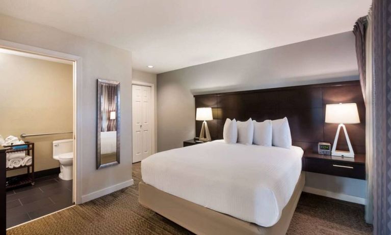 Double bed guest room in Sonesta ES Suites Dulles Airport, with tall mirror and ensuite bathroom.