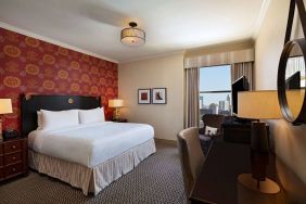 The Stephen F Austin Royal Sonesta Hotel double bed guest room, including window and workspace desk and chair.