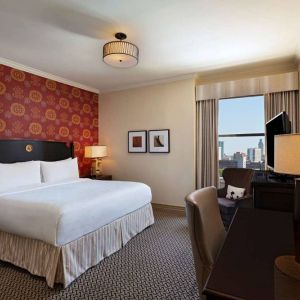 The Stephen F Austin Royal Sonesta Hotel double bed guest room, including window and workspace desk and chair.