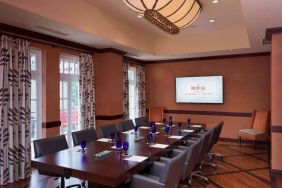 The Stephen F Austin Royal Sonesta Hotel meeting room, with long wooden table, ten swivel chairs, and wall-mounted television.