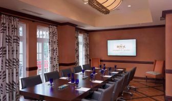 The Stephen F Austin Royal Sonesta Hotel meeting room, with long wooden table, ten swivel chairs, and wall-mounted television.