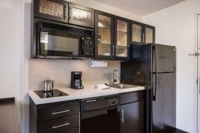 Sonesta Simply Suites Arlington guest room kitchen area, including fridge-freezer, oven, hob, and microwave.