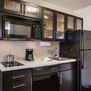 Sonesta Simply Suites Arlington guest room kitchen area, including fridge-freezer, oven, hob, and microwave.