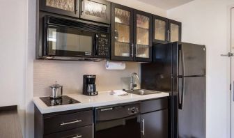 Sonesta Simply Suites Arlington guest room kitchen area, including fridge-freezer, oven, hob, and microwave.