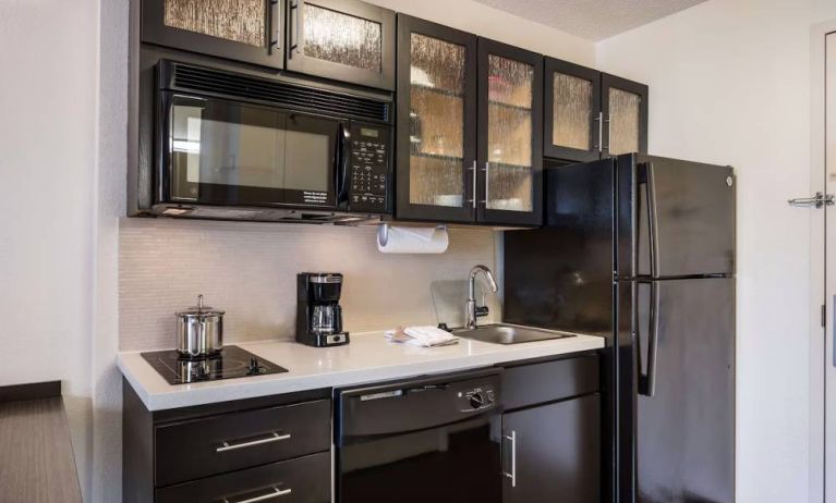 Sonesta Simply Suites Arlington guest room kitchen area, including fridge-freezer, oven, hob, and microwave.