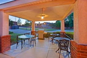 The hotel’s gazebo provides outdoor tables and chairs under cover, with greenery nearby and a barbecue.