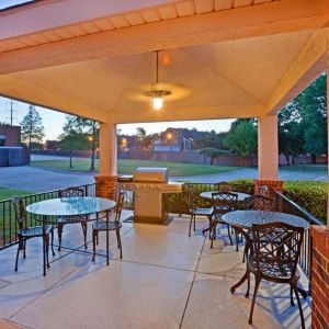 The hotel’s gazebo provides outdoor tables and chairs under cover, with greenery nearby and a barbecue.