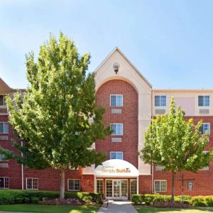 Sonesta Simply Suites Arlington’s exterior has clear signage, beautiful lawns, and towering trees.