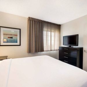 Sonesta Simply Suites Nashville Brentwood double bed guest room, including window and widescreen television.