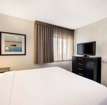 Sonesta Simply Suites Nashville Brentwood double bed guest room, including window and widescreen television.