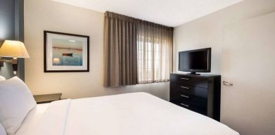 Sonesta Simply Suites Nashville Brentwood double bed guest room, including window and widescreen television.