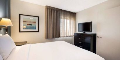 Sonesta Simply Suites Nashville Brentwood double bed guest room, including window and widescreen television.