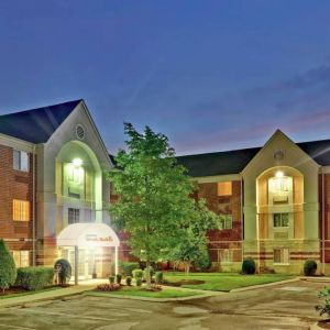 Sonesta Simply Suites Nashville Brentwood’s exterior is brightly lit and has well-tended lawns, bushes, and trees.