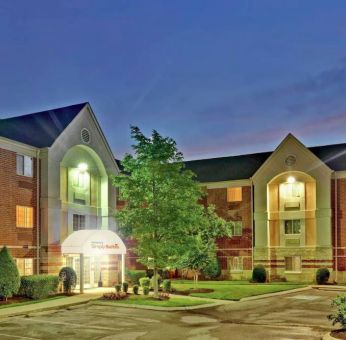 Sonesta Simply Suites Nashville Brentwood’s exterior is brightly lit and has well-tended lawns, bushes, and trees.