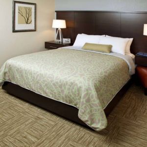 Sonesta ES Suites San Jose Airport double bed guest room, including bedside lamps and an ensuite bathroom.