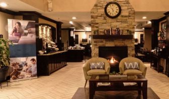 The hotel’s lobby has comfortable seating, a coffee table, reading material, and a cozy fireplace.