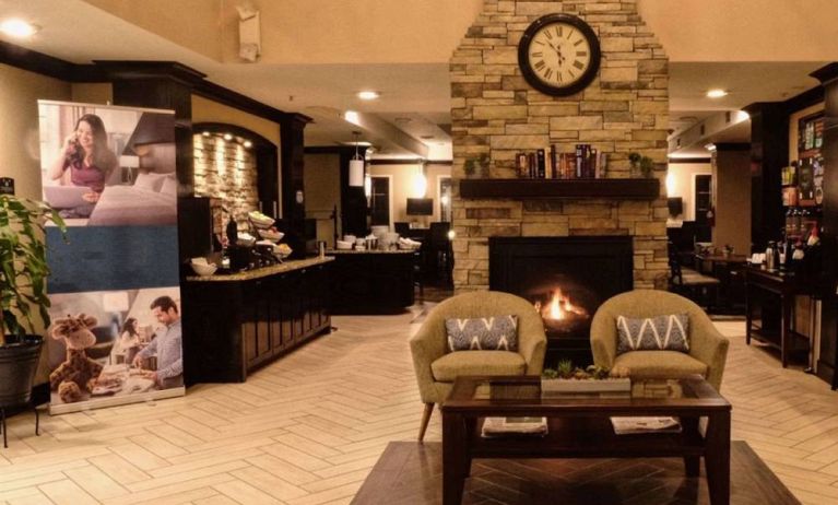 The hotel’s lobby has comfortable seating, a coffee table, reading material, and a cozy fireplace.