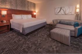 Double bed guest room in Sonesta Select Arlington Rosslyn, furnished with wall art, sofa, and coffee table.