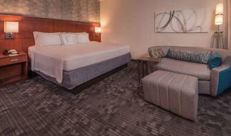 Double bed guest room in Sonesta Select Arlington Rosslyn, furnished with wall art, sofa, and coffee table.