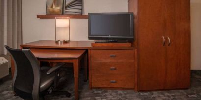 Sonesta Select Arlington Rosslyn guest room workspace, including desk, chair, lamp, and TV.