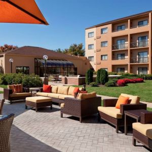 The hotel terrace is furnished with shaded tables and chairs, plus armchairs and sofa seating with adjacent coffee tables.