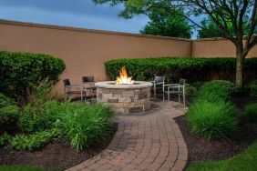 The hotel’s fire pit has chairs and abundant greenery around it.