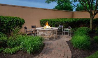 The hotel’s fire pit has chairs and abundant greenery around it.