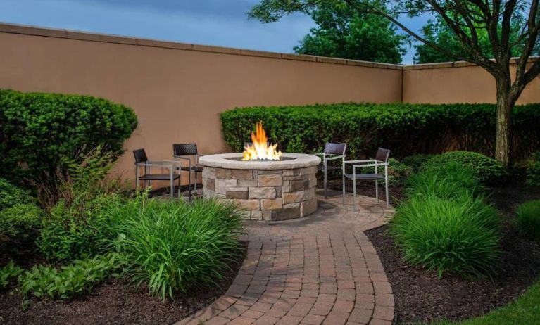 The hotel’s fire pit has chairs and abundant greenery around it.