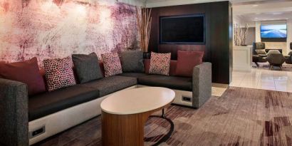 The hotel’s lobby has comfortable sofa seating, a coffee table, and large widescreen television.