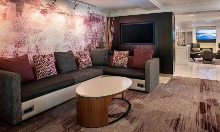 The hotel’s lobby has comfortable sofa seating, a coffee table, and large widescreen television.