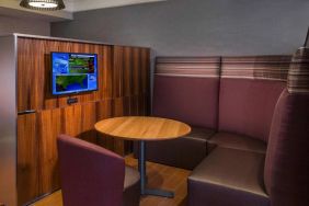 A media pod, featuring coffee table, TV, and comfortable seating where guests can relax and co-work.