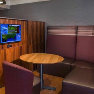 A media pod, featuring coffee table, TV, and comfortable seating where guests can relax and co-work.