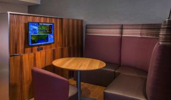 A media pod, featuring coffee table, TV, and comfortable seating where guests can relax and co-work.